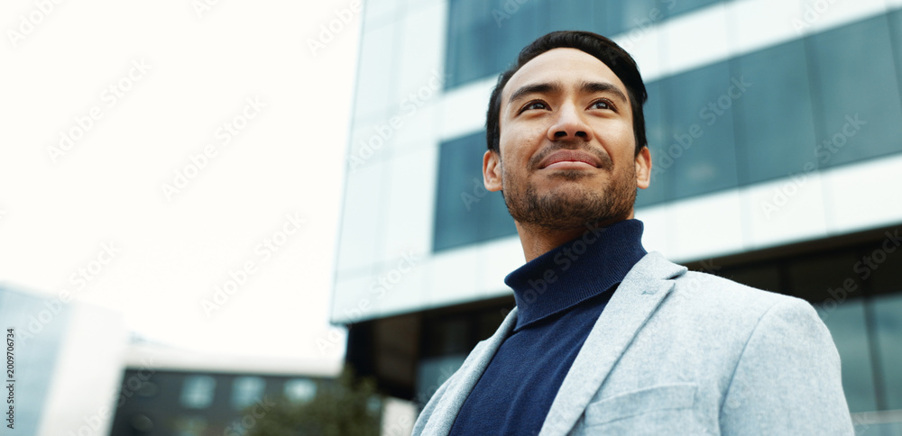Obraz premium Thinking, business and man in city for property investment, urban development and opportunity. Low angle, space and corporate person with inspiration, ambition or reflection for real estate expansion