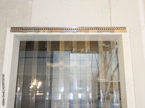 Industrial plastic strip curtain hanging in a doorway for temperature control and dust prevention