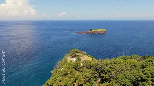 Aerial View of Scenic Tropical Coastline with Lush Headland and Distant Islet in Blue Ocean