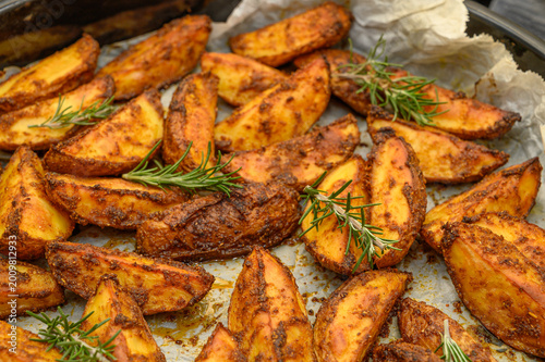 Photography Herb-Roasted Potato Wedges with Rosemary on Wooden Surface