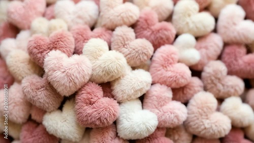 A vibrant collection of plush heart-shaped decorations in soft pastel colors, creating a cozy atmosphere