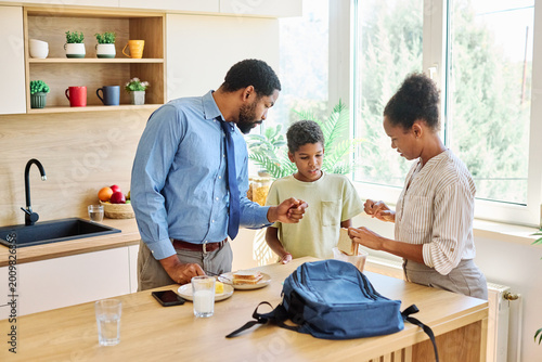 Photos Father businessman mother and father helping son to get ready for school,   help