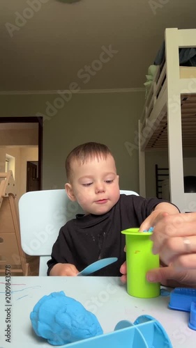 Toddler playing with blue kinetic sand at home