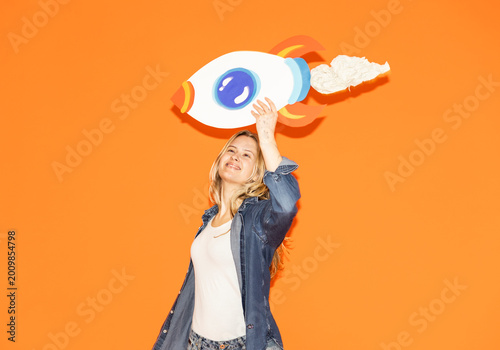 Woman holding a handmade paper rocket to symbolize success and growth