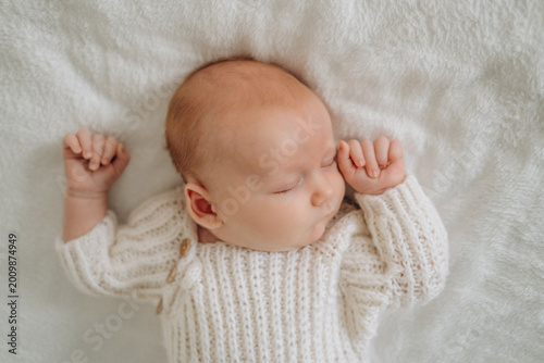 a newborn baby is sleeping, a sweet healthy baby's sleep on a white bed, space and room for text