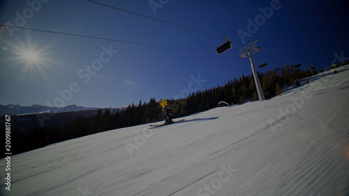 Fotografi Dynamic downhill skiing on a bright, sunny winter day, a thrilling snow sport experience