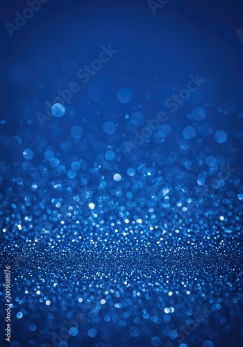 Abstract blue background featuring scattered vibrant bokeh lights and shimmering festive particles for digital design overlay. The intense glimmer is appealing ,festive ,dark ,sparkle