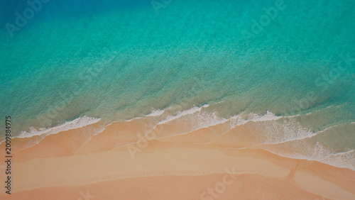 Canvas Print Aerial view of a pristine tropical beach, turquoise ocean waves gently lapping against soft golden sand, a serene coastal landscape for travel and vacation themes