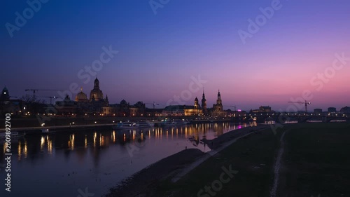 Day-to-night hyperlapse of Dresden skyline along the Elbe River, Germany. The scene captures a smooth transition from sunset to dusk and into night, with the historic Old Town skyline including Frauen