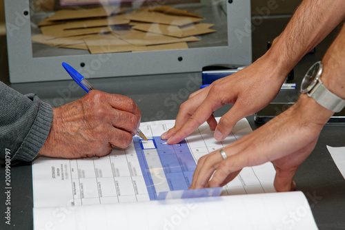 un homme signe apès avoir voté durant des élections, 