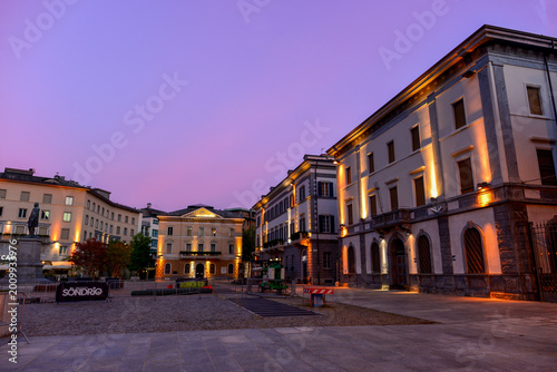 Obraz na plátně Abendliche Piazza Garibaldi in Sondrio mit beleuchteten historischen Gebäuden, I