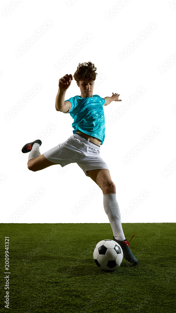 Obraz premium Teal jersey soccer player leaping over ball on grass field with copy space. Concept of sports ads, training promo, youth league banners, athletic motivation and active lifestyle campaigns.