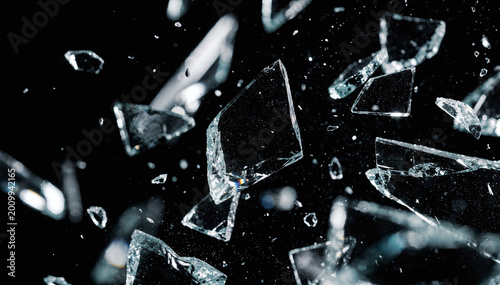 Photos Abstract image of shattered glass fragments scatter against a dark background