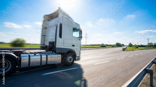 фотографія Sleek modern white semi-trailer truck cab speeding on a multi-lane highway under a clear blue sky, motion blur