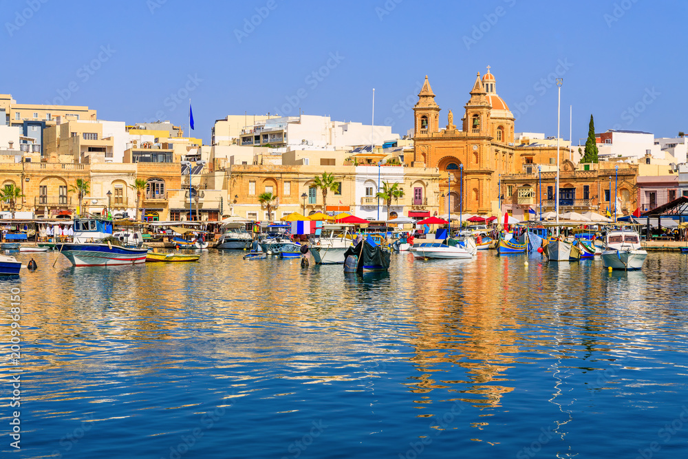 Naklejka premium Malta, Marsaxlokk. Traditional fishing boats in the Mediterranean Village.