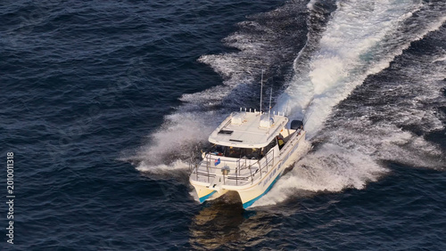Foto High Angle Aerial View of Fishing Charter Boat Cruising Open Ocean