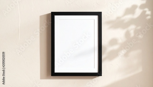 minimalist blank black picture frame mockup on beige wall with soft natural lighting