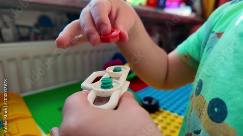 Child playing toy car wheel close up kid hands turning bolt fine motor skills learning development educational play toddler activity