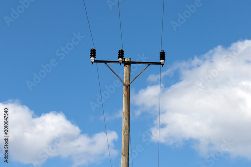 An overhead power pole carries electricity over distances, using wood, metal, or concrete structures with insulators that prevent current flow, safely delivering energy from plants to homes and busine