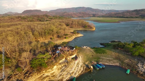 Bird flying above tropical island in Central America. 
Aerial drone view of the islands on Lago Suchitlan in El Salvador. The Cerrón Grande Reservoir, also known locally as Lake Suchitlán