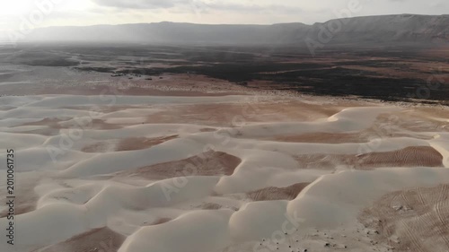 Aerial video flight over vast desert sand dunes and dry barren plains on socotra island yemen, perfect for travel documentaries, alien planet landscapes or nature exploration backgrounds