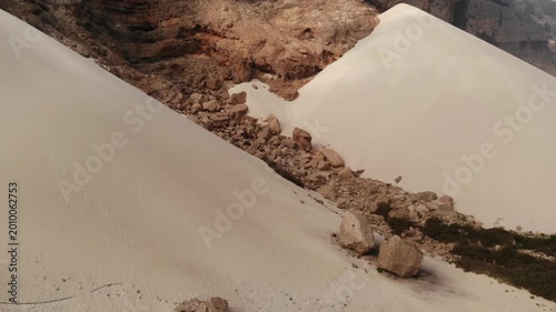 Panoramic aerial video of dramatic sand dunes meeting rocky mountains on Socotra Island, highlighting unique desert landscapes and geological formations