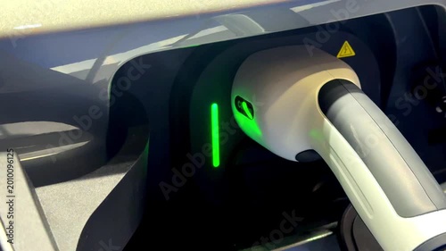 Close up Electric Vehicle charging in station with power supply plugged into an electric car being charged