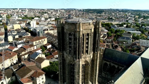 Gothic cathedral tower and transept structure in Limoges seen from a high altitude. Religious monument and surrounding city buildings in a top-down view.