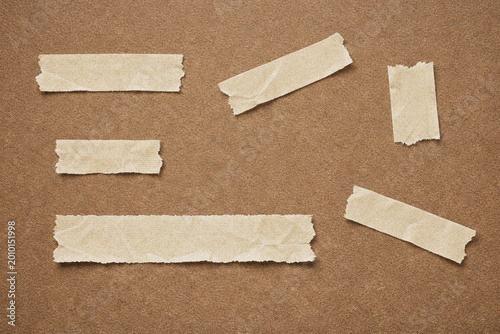 Fotografie Torn paper strips on brown background.