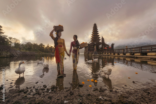 Bali Lady in Traditional dress walk in old temple, indonesia