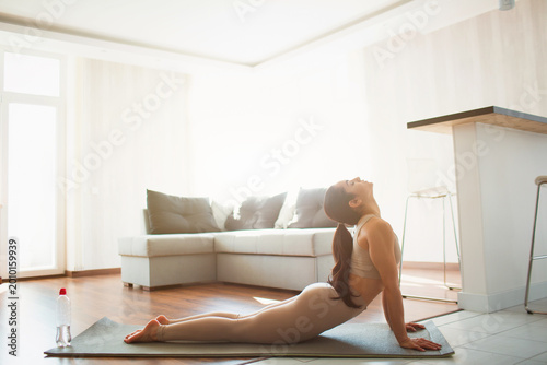 Cuadro en lienzo Young woman doing yoga workout in room during quarantine