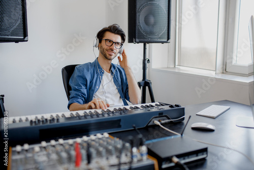 Obraz na plátně Male music arranger composing song on midi piano and audio equipment in digital recording studio