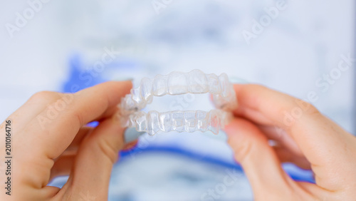 Clear aligners for orthodontic teeth straightening held by patient in a clinic