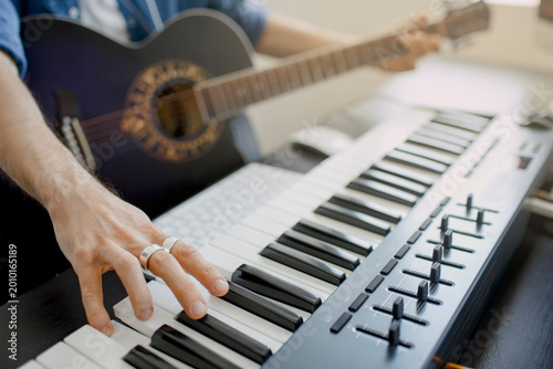 Tableau sur toile Man plays guitar and produce electronic soundtrack or track in project at home