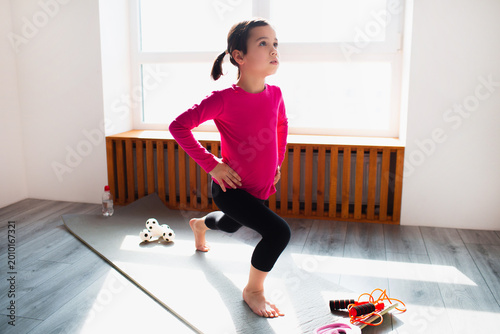 Cuadro en lienzo Little girl forward lunge workout at home