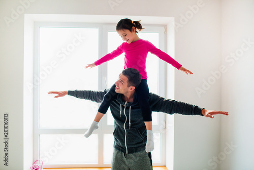 Fotografía Young father and his cute little daughter have workout at home