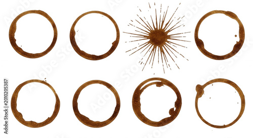 A collection of brown coffee cup ring stains and a sunburst splash mark isolated on a solid black background, top-down view