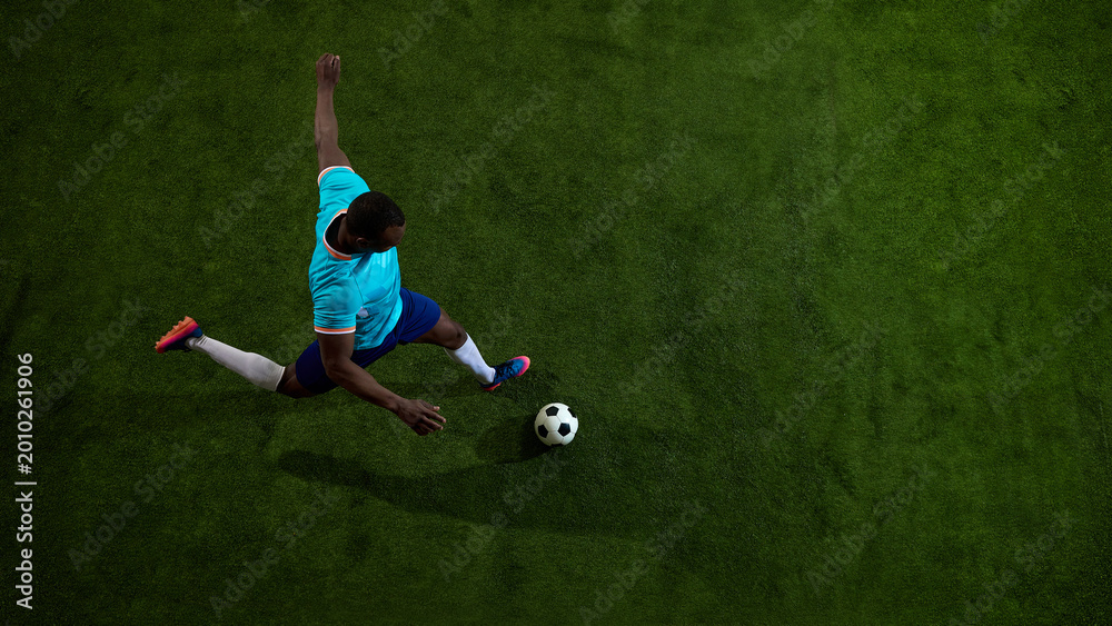 Fototapeta premium Overhead soccer player kicking ball on green field with wide copy space. Concept of football training, tactical sport layout, academy coaching, match preview and gear campaign.