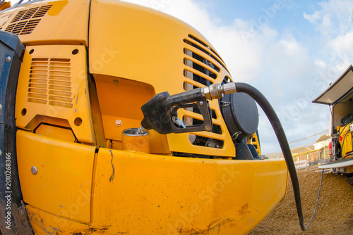 Photos Construction equipment is being refueled at a work site during the day under a c