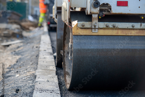 Bild auf Leinwand Road construction work seen from the ground with a roller compacting asphalt nea