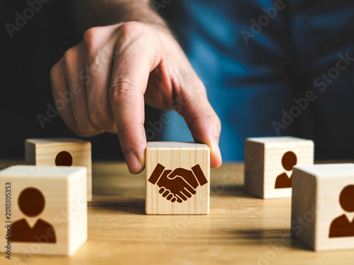 Business partnership handshake on wooden block, team building and agreement concept