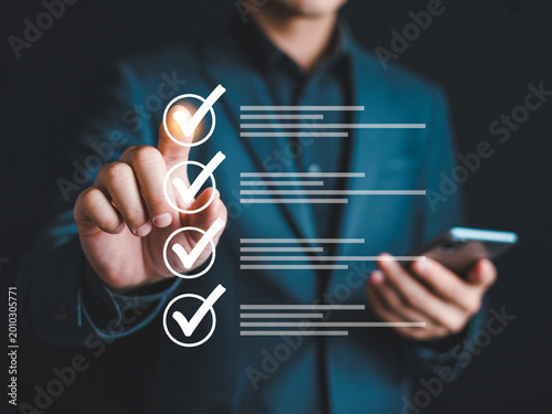 Businessman interacting with digital checklist on touchscreen for task management and productivity