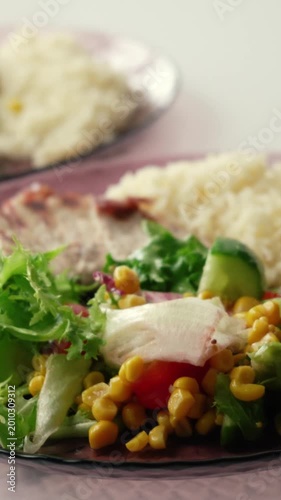 A morning breakfast with rice, fresh vegetables, and meat. Healthy food for weight loss. A delicious dish with lettuce, tomatoes, and corn.