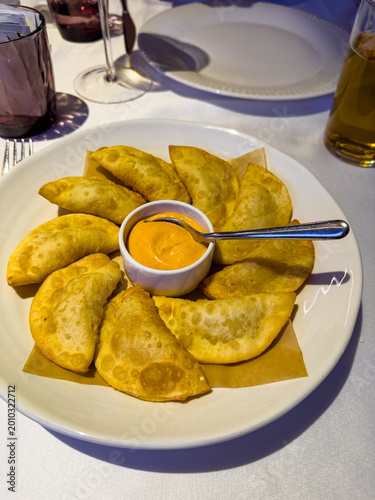 Deliciously Golden Fried Empanadas Served with Spicy Dipping Sauce on a Elegant Table Setting, Perfect for Sharing and Enjoying Exotic Flavors