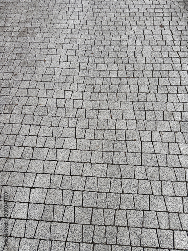 A Close-Up View of Textured Paving Stones Arranged in an Intricate Pattern on a Grey Surface, Showcasing the Unique Design of Modern Urban Pavements