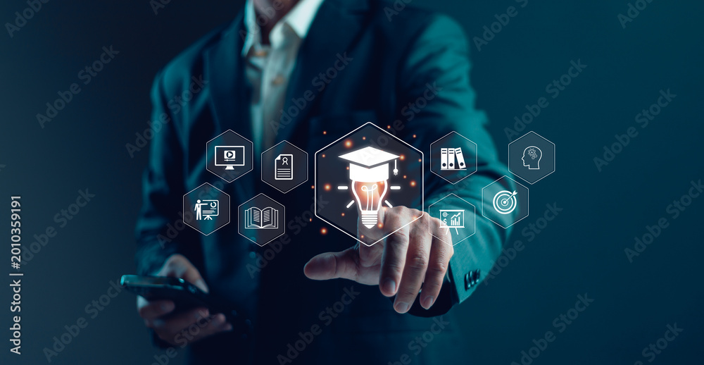 Naklejka premium Businessman touching digital education technology interface with graduation cap, light bulb, online learning icons, knowledge management, innovation training and smart corporate development