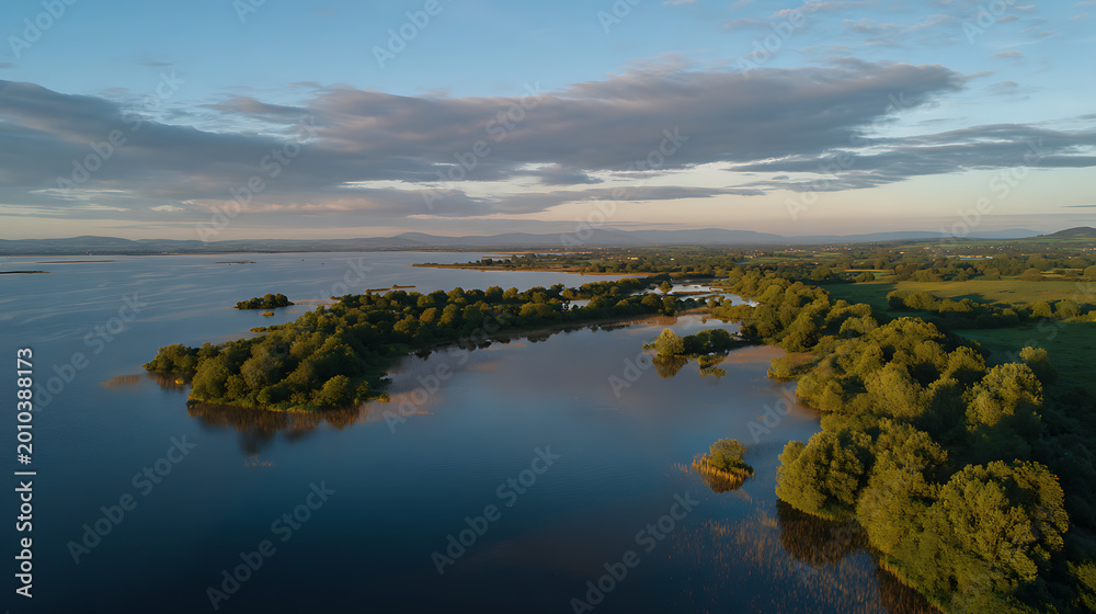 Obraz premium Aerial View of Serene Lake and Lush Green Forest During Golden Hour, Calm Waters Reflecting Sky, Beautiful Nature Landscape at Sunset