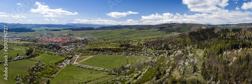 Ultra-wide aerial panoramic view of Levoca city, Marianska hora pilgrimage site, and the High Tatras mountains in spring, Slovakia