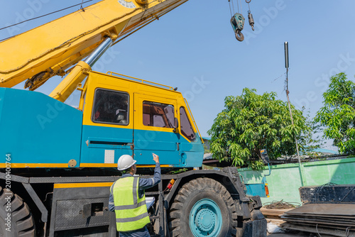Tableau sur toile Construction worker and rigger in hard hats performing safety inspection beside