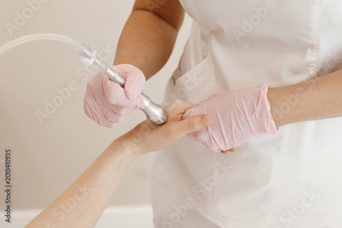 Professional female cosmetologist doing hydrafacial procedure in Cosmetology clinic.